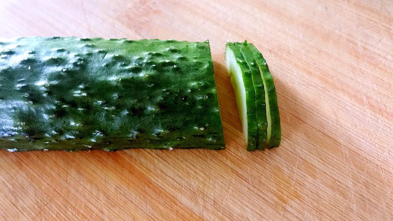 喜欢吃黄瓜的人注意了，这种做法让您吃得与众不同,均匀的切三片，第三刀切断。