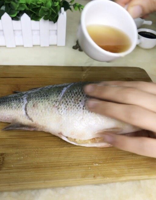 清蒸鲈鱼,撒上盐和<a style='color:red;display:inline-block;' href='/shicai/ 718'>料酒</a>，鱼的两面都涂抹均匀。