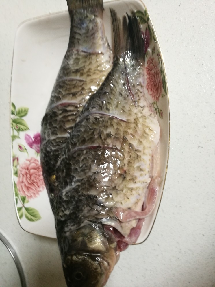 豆瓣鲫鱼,捡去姜片,在鱼身上抹一层芡粉。锅中放油,烧至七分热,鱼下锅微炸,捞出。
