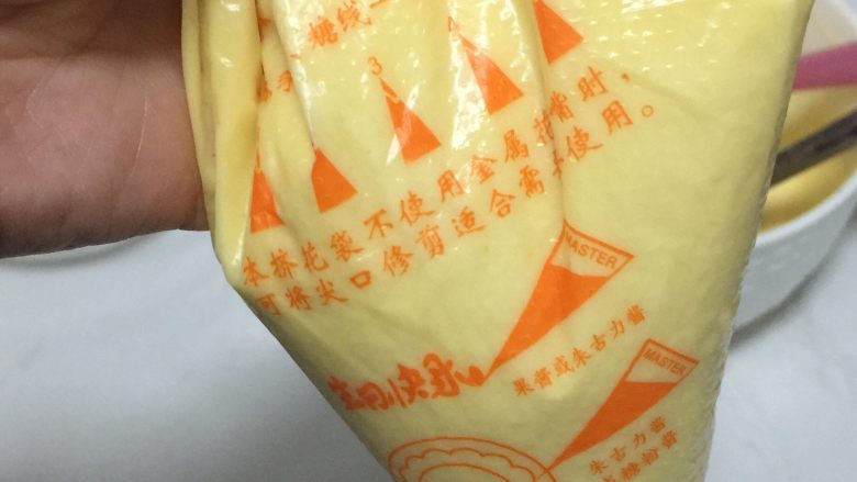 巧克力蛋糕棒棒糖,把面糊装入裱花袋中,中间不要留有空气。底部剪一个小口