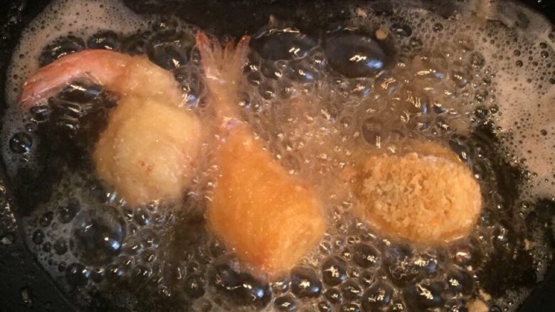 芝士虾球,炒锅放油烧热,底部倾斜,这样可以少放些油,避免浪费。等油温上升,以手掌放在锅上有热感为宜,或者木筷插入油内,周围有气泡即可下锅炸。中火炸熟,大火上色。