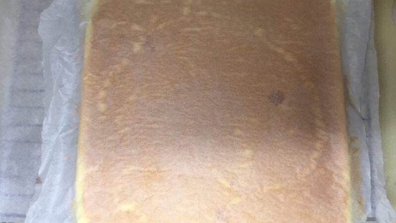 肥厚肉松卷,烤熟后，立马盖上准备好的油纸，倒扣在晾网上。