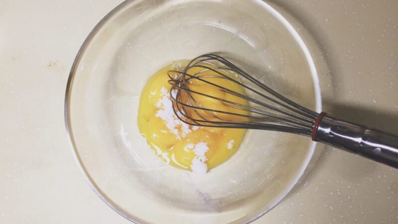 肥厚肉松卷,蛋黄里加入少量砂糖，搅拌均匀。