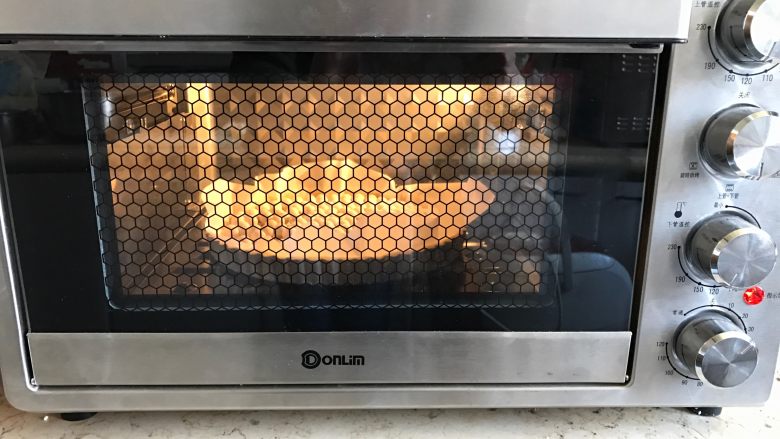 肉桂苹果派,铺上油纸压上小石,放入烤箱170度烘烤10分钟定型。