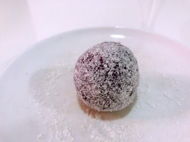 紫薯草莓雪球,放到盘里轻轻地摇动,直至整个紫薯都均匀粘上椰蓉。