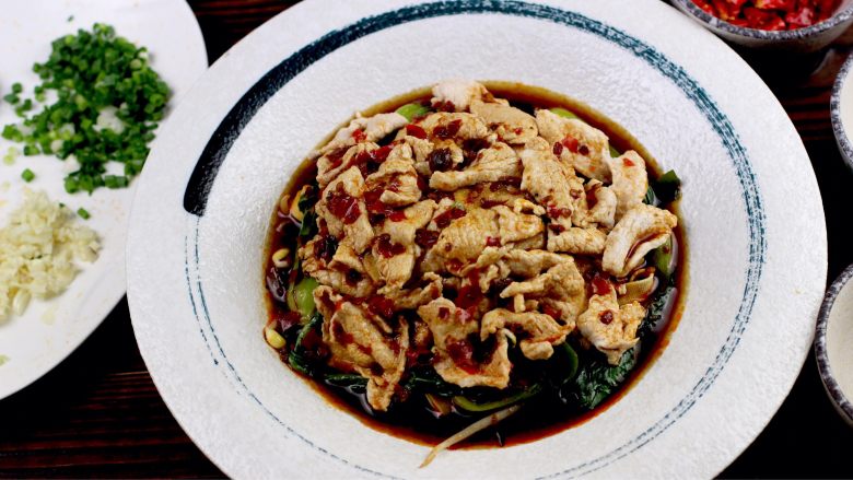 水煮肉片,将肉片盛入盘中摆放蔬菜上面,将汤汁淋入,