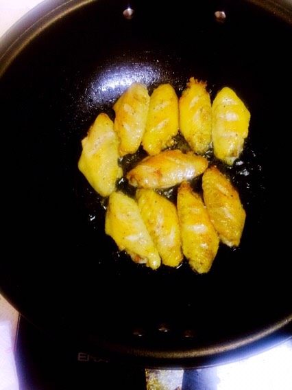 可乐鸡翅
,在锅中倒入适量的油，用吸水纸吸取鸡翅中的水后放入锅中，煎至两面金黄

