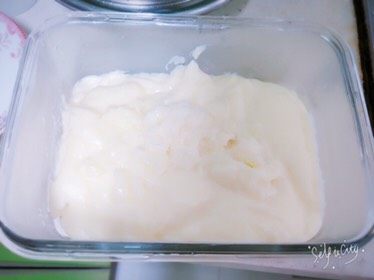 椰蓉牛奶小方,准备一个玻璃饭盒,在底部撒满椰蓉,将小奶锅里的内容物倒入饭盒中,将饭盒轻轻左右晃动使其平整。盖好盖子放入冰箱冷藏