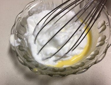 蓝天白云蛋糕卷,取出30克打发好的蛋清到小份的蛋黄糊里,用刮刀翻拌均匀。
