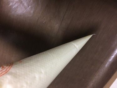 蓝天白云蛋糕卷,把翻拌均匀的蛋糕糊装进一个裱花袋,裱花袋前端剪一个小口。