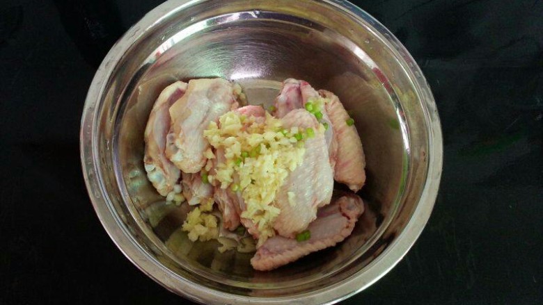 可乐鸡翅,将鸡翅放盘内,再加入姜、蒜、小葱。