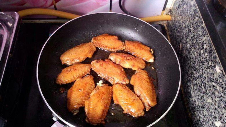 可乐鸡翅,用小火焖至汤汁变浓时即可收火装盘。