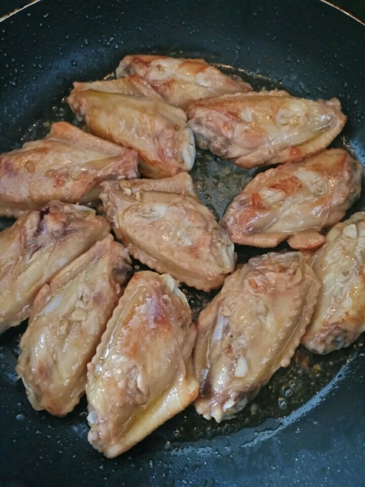 蜜汁鸡翅,锅内加油烧八成热，放入鸡翅，两面煎至金黄