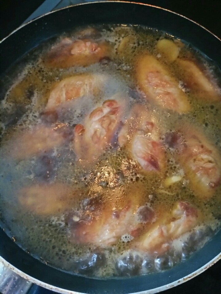 蜜汁鸡翅,把刚才腌制鸡翅的汁倒进锅内翻炒，加入开水莫过鸡翅就行，加入<a style='color:red;display:inline-block;' href='/shicai/ 762'>老抽</a>，盖上盖子大火10分钟