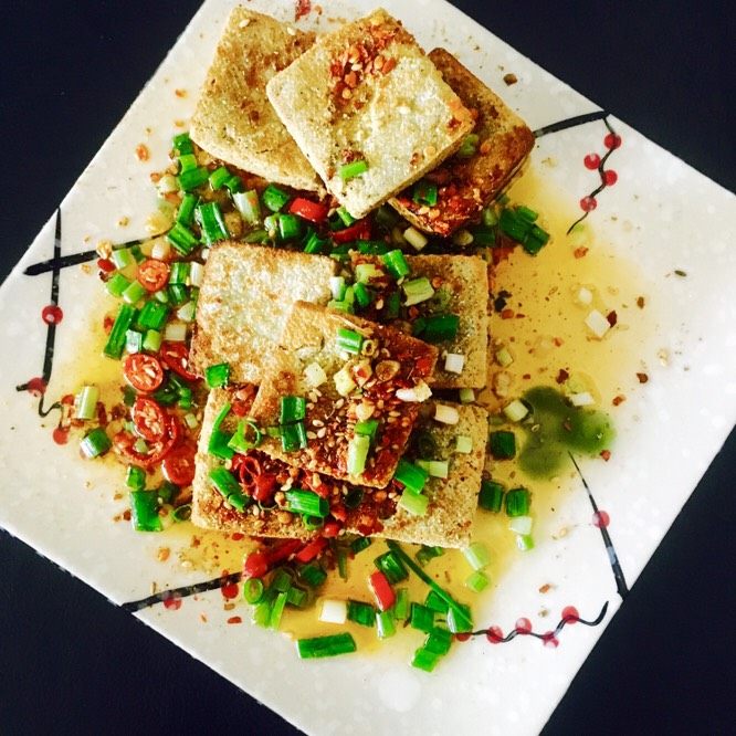 香煎臭豆腐,锅内油烧开，用勺子舀出浇在摆好盘的豆腐块上即可。