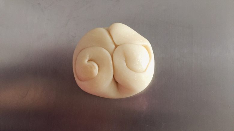 蛋黄酥,取一份酥皮,中指从中间压下,两边向中间卷好(如图)