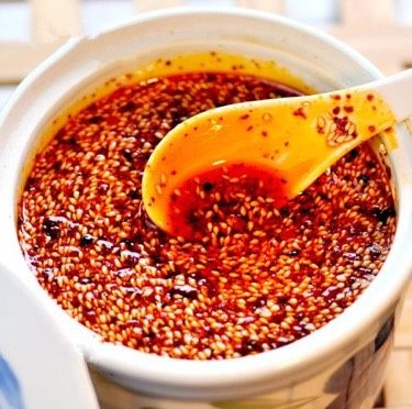 秘制陕西正宗凉皮专用辣椒油（绝密秘方）,泼油浸渍辣椒面：将精心炼制的香油高温 倒入拌过调料的辣椒面，一边倒入一边不停的用筷子搅拌均匀。待油全部倒入辣椒面里后，立即加入 <a style='color:red;display:inline-block;' href='/shicai/ 13909'>镇江香醋</a> 20g ，然后撒上 炒熟的 <a style='color:red;display:inline-block;' href='/shicai/ 678'>白芝麻</a> 80g  ，同样搅拌均匀，盖上盖子密封，静置一晚（12-24 小时都可）。 练好的辣椒油不宜立即使用，因为香味不醇厚，还未充分散发出，最好加入陶罐或有盖的容器，加盖自然冷却浸渍 12 到 到 24 小时，这样就做好了，因为加入了紫草，成品效果油色明亮，色泽金红，香味醇浓，辣味突出。