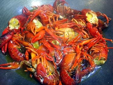 私房香辣小龙虾,锅里注油,稍稍多一点,烧八成热,倒入龙虾炸至变红;