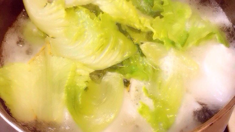 葱香水煮鱼,生菜焯水平铺在碗底装饰,再将煮熟的鱼片铺在生菜上,撒上京葱,小红椒沫备用。
