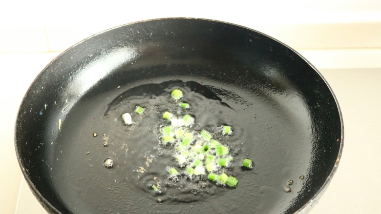 香菇酱五彩菠萝饭,炒锅放油,爆香葱末。