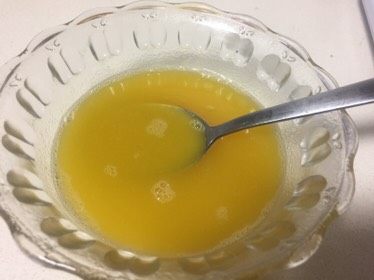 百香果芒果慕斯,一个百香果过滤成百香果汁,一片吉利丁片冷水泡软倒掉冷水隔热水融化,再加30克纯净水,三者混合均匀就制成了慕斯镜面。