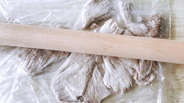 自制蓬松的海苔肉松,放进保鲜袋里,用擀面杖擀碎。