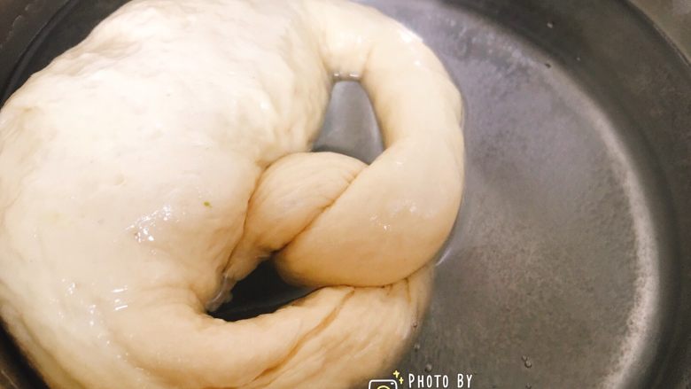 非传统意义上的德国碱水面包——纽结面包（小苏打版）,用漏勺将面团放入小苏打水中依次浸泡，浸泡的时候用漏勺压一下，正反面可以同时浸泡到。
