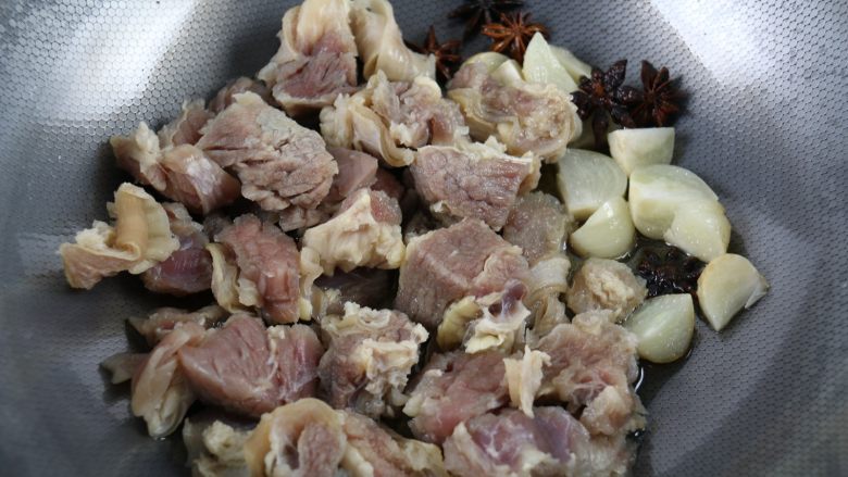 土豆萝卜焖牛腩,炒出香味后,加入牛腩,改中火,继续翻炒5分钟左右,能闻到很香的牛肉味了,牛油也被逼出了少许。