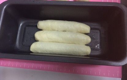 性感的豹纹控吐司面包,放入内壁四周涂了油的吐司盒中。底下一层铺满三条,如图