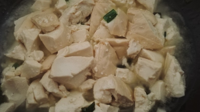 鸡蛋刨豆腐,热锅,加少许底油。油微热时加入一半的小葱末,炒出香味。然后放入压碎的豆腐翻炒几下。