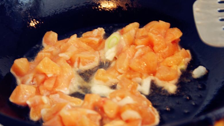 五彩鸡丁焖饭,炒锅里倒油,放入腌制好的鸡丁翻炒。