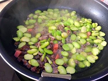 蚕豆饭,锅里倒入适量的油,比一般做菜的量少一点,烧六成热,放入腊肉跟蚕豆翻炒下; (可以尝下蚕豆有点粉粉的口感就可以)