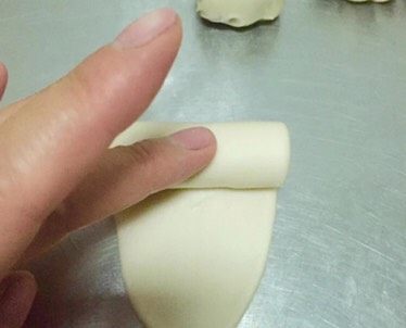 豆沙酥,用擀面杖将醒发好的小面团擀成牛舌状，擀的时候收口朝上，自上向下卷起来继续醒发15分钟。