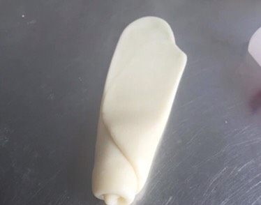 豆沙酥,将醒发好的面团再次擀长，卷起，盖上保鲜膜醒发15分钟