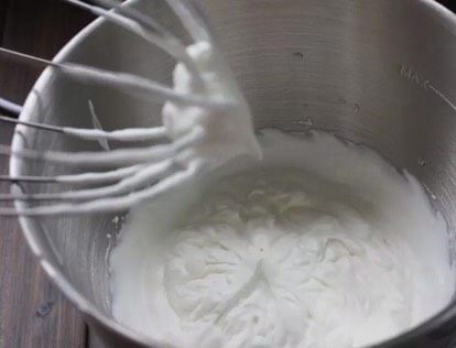 芒果草莓双味蛋糕卷,蛋糕出炉后倒扣,撕去油纸。晾至不烫手。这时候取<a style='color:red;display:inline-block;' href='/shicai/ 8197'>淡奶油</a>,加入糖,打发,直到提起打蛋器有小尖角即可