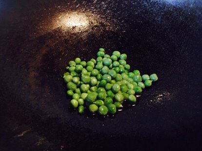 蚕豆饭,剩余还有点油,倒入豌豆煸炒,这时,小豌豆会在锅里跳跃,可以加盖,两分钟好来。