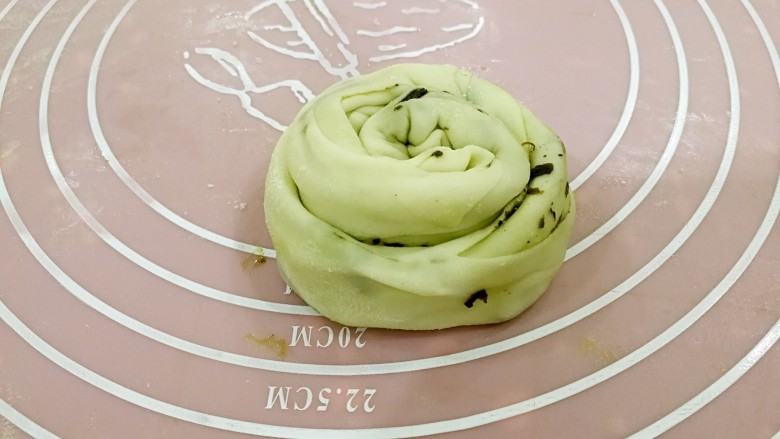 橄榄菜手抓饼,把面皮卷成条状后,再卷成厚饼状。