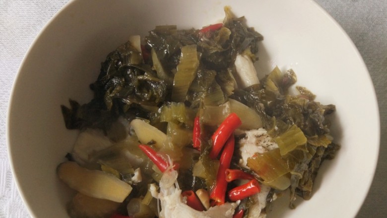 酸菜鱼,汤熬好后,用漏勺把酸菜等捞起,放在大汤碗里面,锅内只剩下鱼汤
