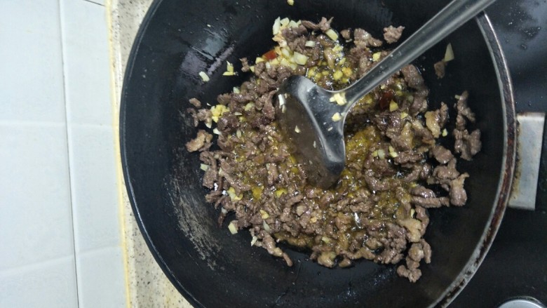 回味无穷的私房牛肉,油开后,把牛肉和姜蒜一起翻炒