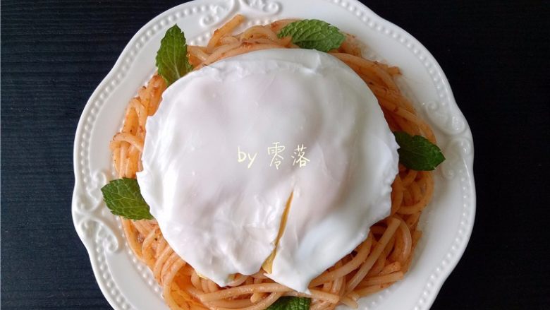 水波蛋意面,鸡蛋磕进锅里,煮熟,捞出,放在意面上;旁边装饰薄荷叶;