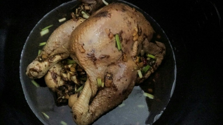 玫瑰豉油鸡,腌制完成后,首先把酱料装进鸡的肚子里,剩余的酱汁可选择一并倒入电压力锅内胆内或者装起备用(若选择酱汁装起备用,为防止煮的过程中鸡会烧焦,需要在电压力锅内胆中垫上之前备好的姜片),盖上锅盖,开启电压力锅“肉/鸡”功能。