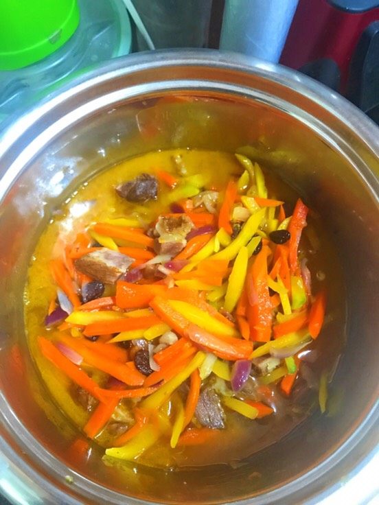 电饭锅版抓饭,倒入之前的炒好的羊肉块电饭锅中加水煮开,加入适量砂糖,加入洗净的葡萄干(加入很香甜可口哦)