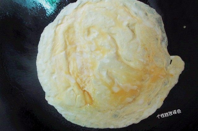 蛋皮包饭,用中火将不粘锅烧热,放油,倒入蛋汁,将锅旋转,令蛋汁铺平成一圆饼,蛋煎至九成熟,翻面,用小火煎至鸡蛋熟;