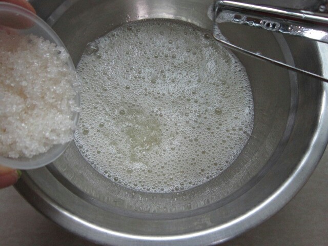 黑芝麻纸杯蛋糕,<a style='color:red;display:inline-block;' href='/shicai/ 595'>柠檬</a>滴入蛋白,用打蛋器打至鱼泡角,然后加入3分之一白糖接着打。