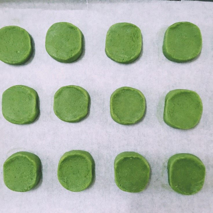 【网上厨房独家】微苦抹茶沙布列酥饼,取出面团外面洒上适量的砂糖作为装饰,切成厚大约1cm的小饼,放入铺好油纸的烤盘中