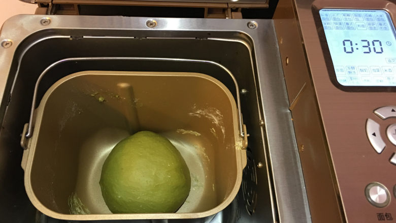 抹茶凤梨全麦面包,将面团整圆后放入面包机中,使用面包机发酵菜单进行一次发酵,时间为30分钟。