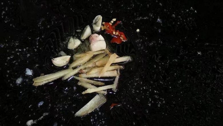 培根炒手撕包菜,热锅下油爆香蒜,泡椒和姜