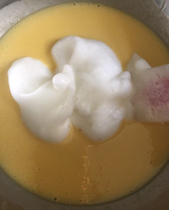 家庭版豆乳盒子,取三分之一的蛋白到蛋黄糊中,用刮刀翻拌。先取一些蛋白混合,是让混合好的糊状态更接近蛋白