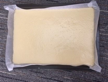 家庭版豆乳盒子,烤盘铺上油纸,倒入面糊,待面糊流淌均匀,震出气泡,几下就可以,不要太多次