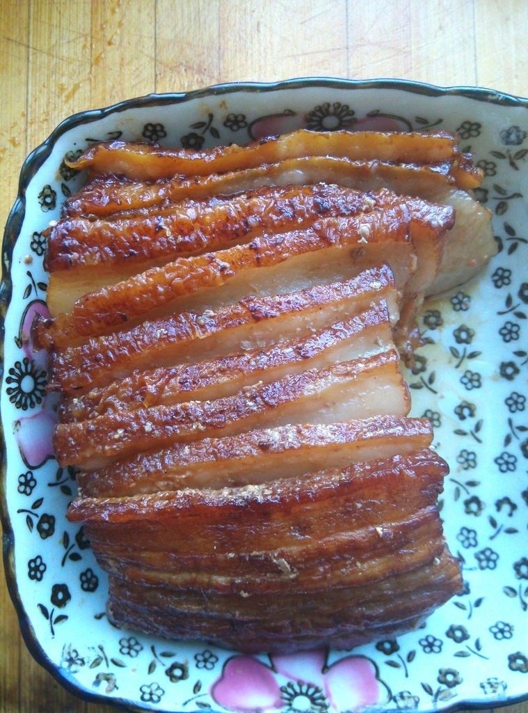家常南乳扣肉,将汤汁倒在另外一锅里,用另一个盘子扣在上面,翻转方向,肉就扣进盘里了,此时肉皮朝上。为了让每片肉都入味,我把粘在一起的肉片稍稍分开了一点儿,